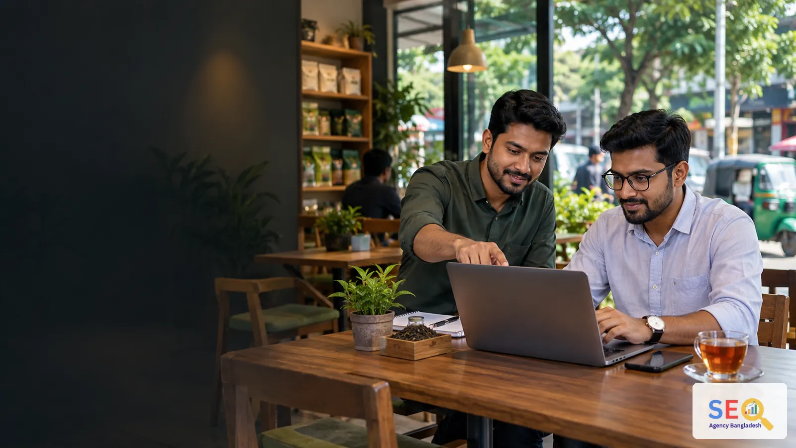 SEO consultant reviewing online growth with a Sylhet business owner in a modern tea and retail setting